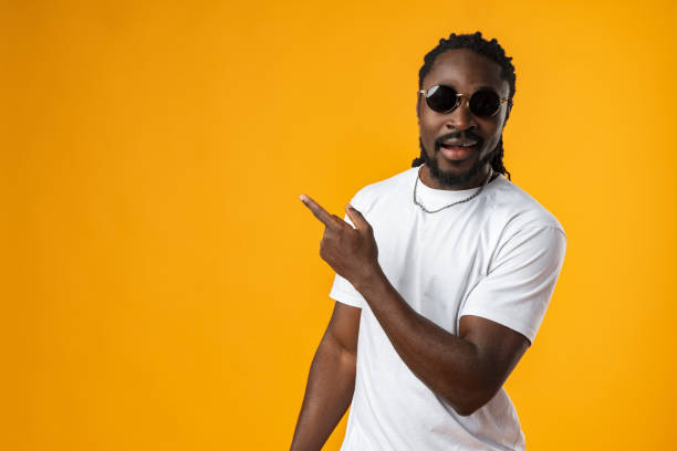 istock African man with beard pointing to copy space against yellow background 1465934829