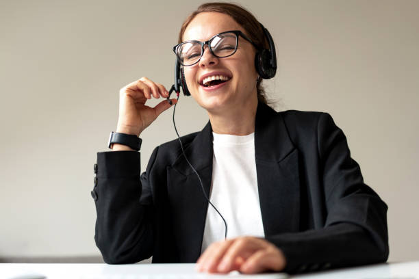 istock Businesswoman in glasses and headset laughing while web conference. 1465935550
