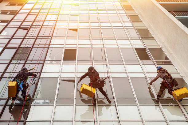 istock Industrial mountaineer laborers hangs on wall cityscape building. Rope access workers on residential house, washing exterior facade glazing. Industry urban works concept. Copy advertising text space 1465938159
