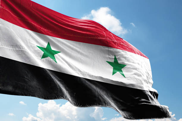 waving syria flag on a crumpled syria flag background stock photo