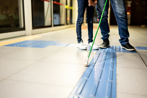 Low section of a blind father and a daughter at a subway station