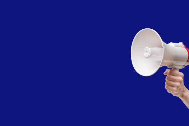 istock Megaphone in woman hands on a blue background. 1465944528