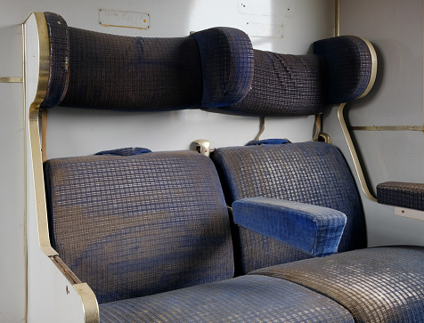 At a lost place. The battered and tattered seats of an old train car.