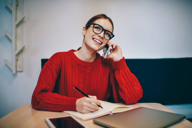 istock Pleased woman making notes during phone conversation 1465947287