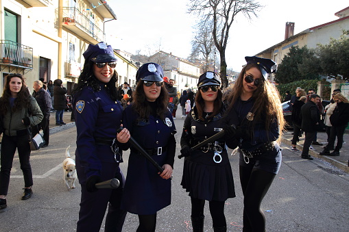 Montemarano,Avellino,Italy- February 23,2020 : Traditional carnival with traditional masks and dances in the historic center of the town of Avellino.Young girls in police costumes.