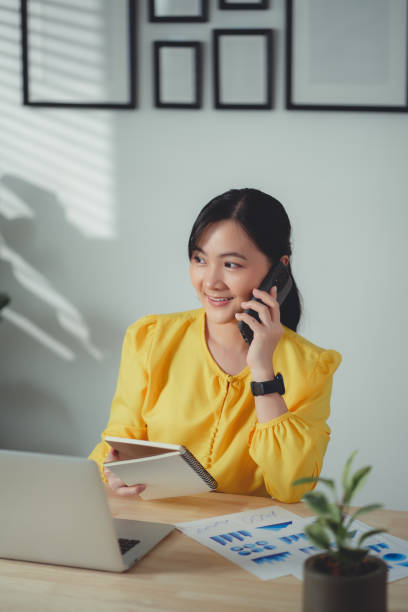 istock Asian woman enjoy with working online and talking on phone at home office. 1465948430
