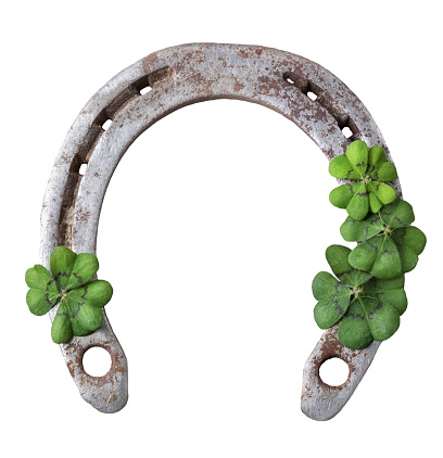 Old rusty horseshoe and four leaf clover isolated on white background