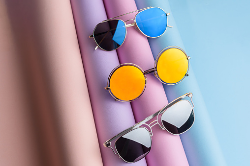 A lot of colorful Fashion Sunglasses put on colorful pastel paper background