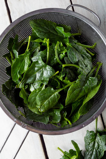 istock Washed fresh mini spinach in a colander on the old wooden table 1465959379