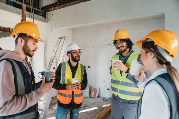 istock Blue collar workers are having a coffee break on the construction site 1465963484