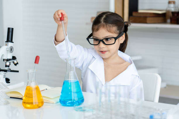 istock Little Asian girl sitting in the science room Learning science, practical, squeezing water from a flask into a beaker as specified by the teacher as a score fun to experiment 1465965944