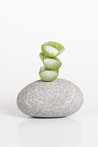 Aloe vera as beauty product ingredient on one gray stone on white background.