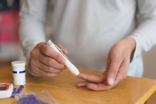 istock young man using blood test kit at home while doing health check . home finger prick blood test . close up, diabetes concept, elderly health care, 1465968908