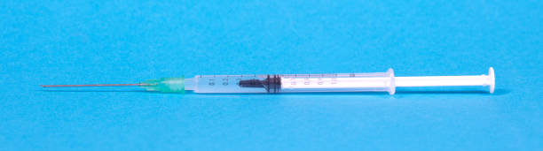 istock Syringe injection or medical needle isolated on blue 1465974114