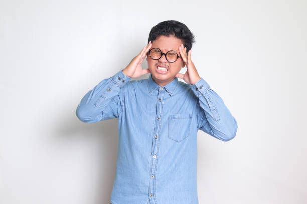 istock Asian man having a migraine, touching his temple 1465978116