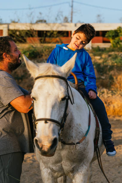 istock Boy with multiple disabilities having an equine therapy session with a physiotherapist. 1465980715