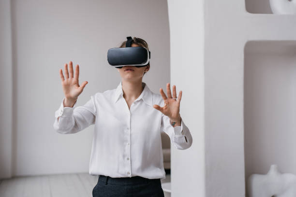 istock Young female student in white shirt and black pants using vr glasses exploring arts and museums standing indoors against wall with ceramics  on shelves. Girl using virtual reality. Education, game. 1465981082