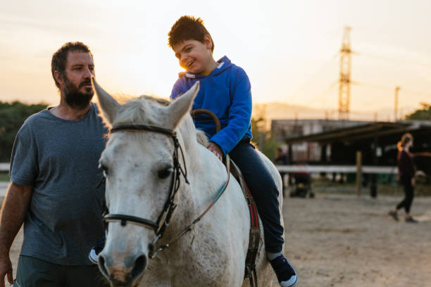 istock Physiotherapist working with a child with a disability in an equine therapy session. 1465981439