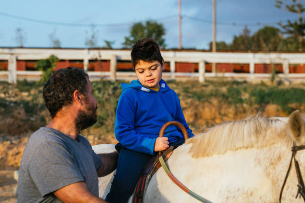 istock Boy with a disability riding a horse during an assisted equine therapy session. 1465984096