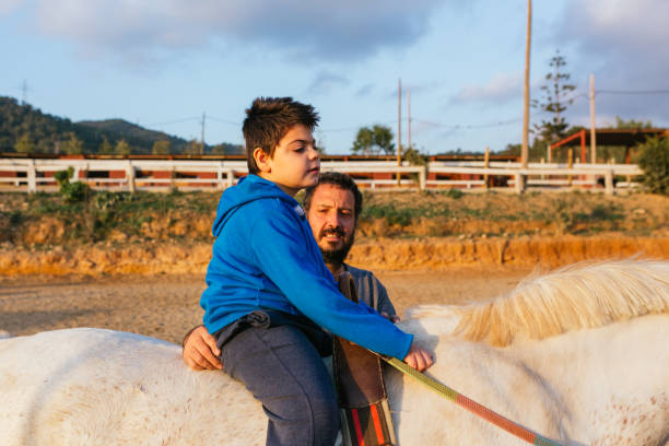 istock Child with disabilities having an equine assisted therapy with a physiotherapist. 1465984240