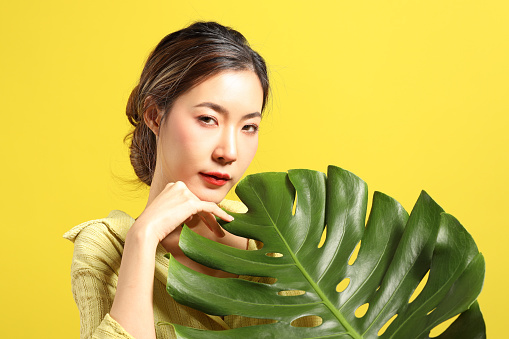 The beautiful  Asian woman showing skin with yellow background.