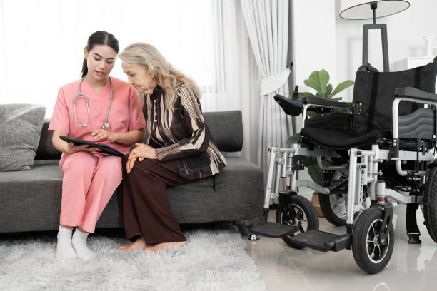 美しい看護師は、自宅でタブレットコンピュータを使用する年配の白人女性の世話をします - ipad senior adult 70s adult ストックフォトと画像