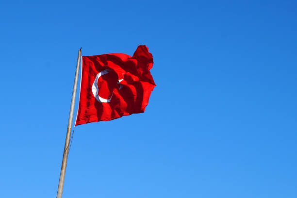 istock Turkish flag waving in the wind against a clear blue sky 1465990784