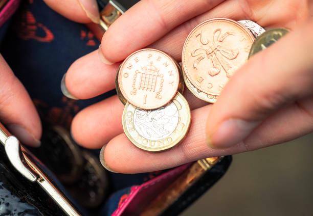 counting the pennies - women savings uk coin imagens e fotografias de stock