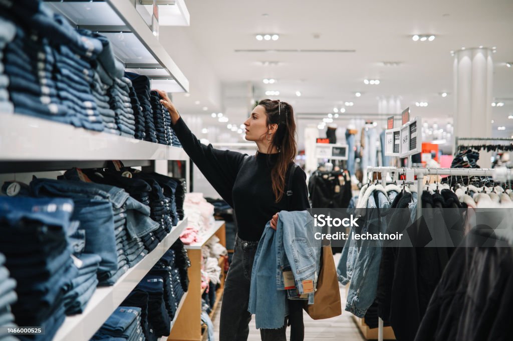 衣料品店でデニムジーンズを買う女性 - 買い物のロイヤリティフリーストックフォト 衣料品店でデニムジーンズを買う女性 - 買い物のロイヤリティフリーストックフォト
