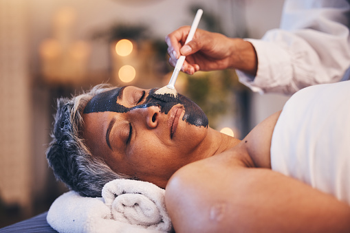 Facial, relax and mask with a woman in spa, lying on a massage table or bed for skincare treatment. Peace, sleeping and wellness with a senior female customer in a health center for luxury care