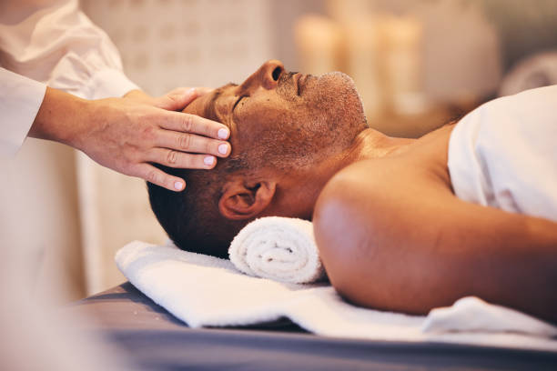 istock Hands, head and massage with a man in a spa on a bed or table for wellness, luxury or stress relief treatment. Relax, zen and beauty with a male customer lying in a health center for physical therapy 1466002902