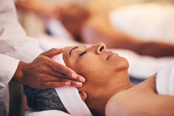 manos, cabeza y masaje con una mujer en un spa para bienestar o tratamiento de lujo para relajarse y descansar. cara, zen y estrés confiaron en una mujer mayor relajándose en un salón de salud para fisioterapia - head massage massaging facial massage beautician fotografías e imágenes de stock