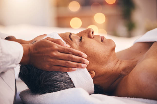 benessere, salute e massaggi, donna anziana in una spa che ottiene una terapia di bellezza di lusso e viso. donna nera matura, zen e massaggiatrice che massaggia l'olio sulla testa per aiutare a rilassare il corpo e la mente per alleviare lo stress. - spa treatment head massage health spa healthy lifestyle foto e immagini stock