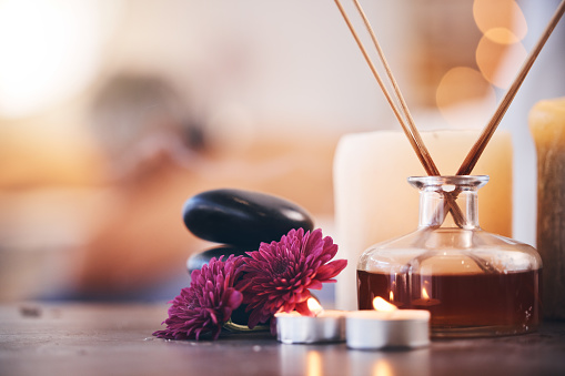 Hot stones, candles and aroma oils in relax spa, hotel salon or self care retreat for healthcare wellness, massage or luxury peace. Zoom, texture and incense scent on table in beauty or empty clinic