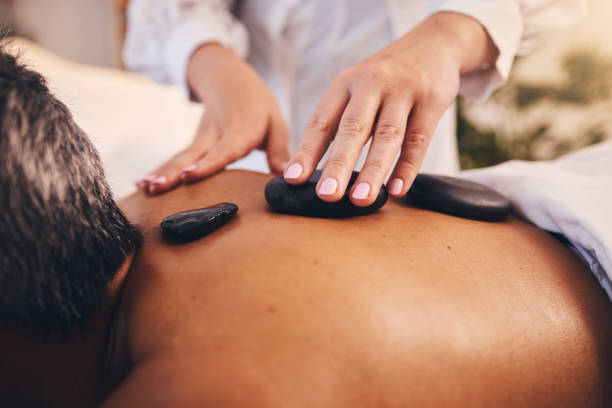 manos, masaje con piedras y terapia de relajación para el cuidado de la piel de belleza o bienestar tranquilo del spa. terapia física, atención médica zen de lujo y curación con roca caliente o desintoxicación natural del cuerpo en un salón de belle - lastone therapy pampering spa treatment women fotografías e imágenes de stock