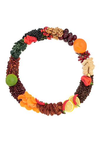 Healthy nourishing food wreath with foods high in nutrients. High in flavonoids, antioxidants, anthocyanins, vitamins, proteins, minerals, fibre. Good health concept. On white.