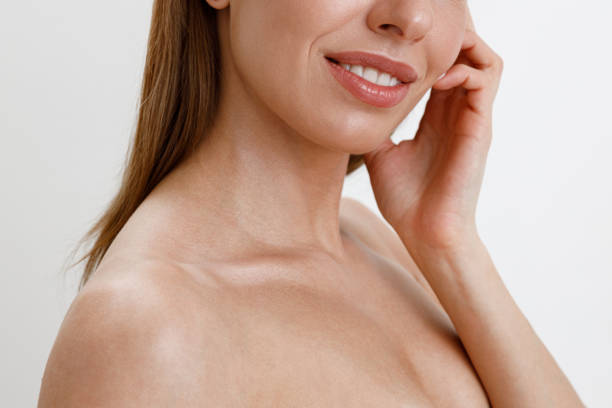 istock Smiling woman touching her perfect face over white studio background. Healthcare routine concept 1466014238