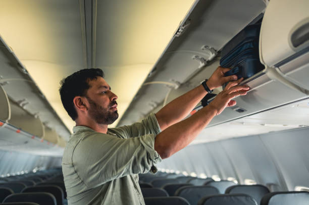 istock tourist picking up suitcase on plane 1466014524
