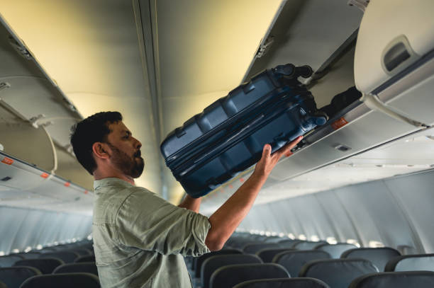 istock tourist picking up suitcase on plane 1466014539