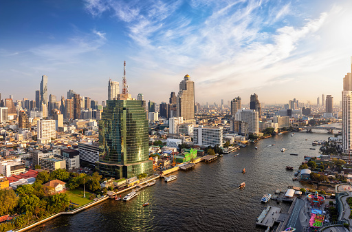 Beautiful panoramic sunset view of the skyline of Bangkok, Bang Rak and Sathon district, Thailand, along the Chao Phraya river