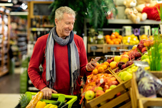 istock Cheerful senior customer purchasing at store, using phone 1466025100