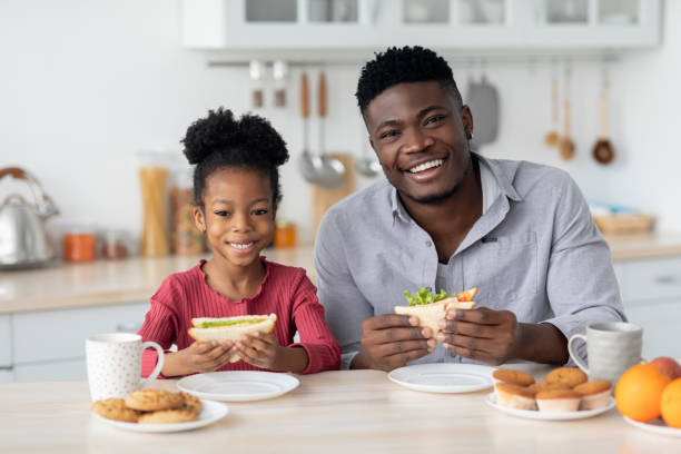 istock Cheerful black father and kid having snack at home 1466025996