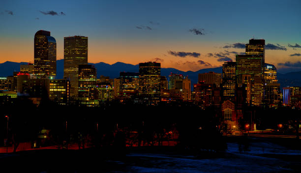 DENVER, COLORADO - FEBRUARY 2023: The beautiful Denver skyline against the warm cast of a winter sunset over the Rocky Mountains.