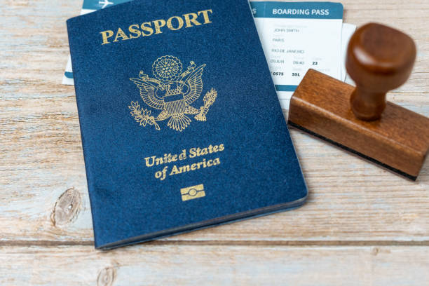 istock US passport and stamp on wooden background. Safe journey with necessary documentation. Top view. Copy space. Your Key to International Travel 1466036485