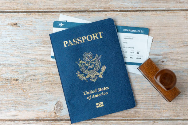 istock US passport and stamp on wooden background. Safe journey with necessary documentation. Top view. Copy space. Your Key to International Travel 1466036489