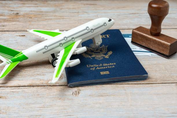 istock US passport and stamp on wooden background. Safe journey with necessary documentation. Top view. Copy space. Your Key to International Travel 1466036549