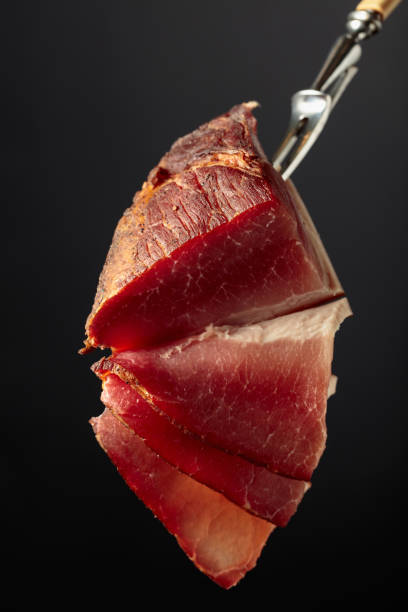 istock Dry-cured pork fillet on a fork. 1466039358