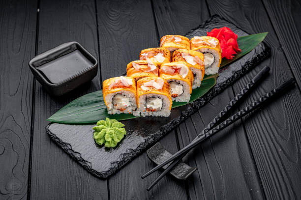 istock Traditional delicious fresh sushi roll set on a black background . Sushi roll with rice, cream cheese, salmon. 1466042100