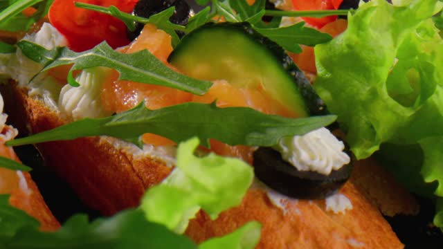 Toasts with salmon, tomato, cream cheese, avocado, olives and rucola