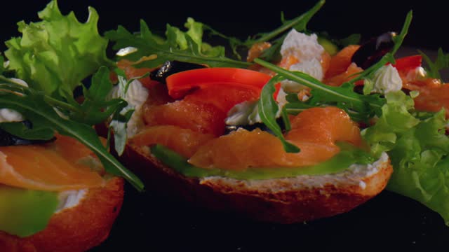 Salmon toasts with tomato, cream cheese, avocado, olives and rucola